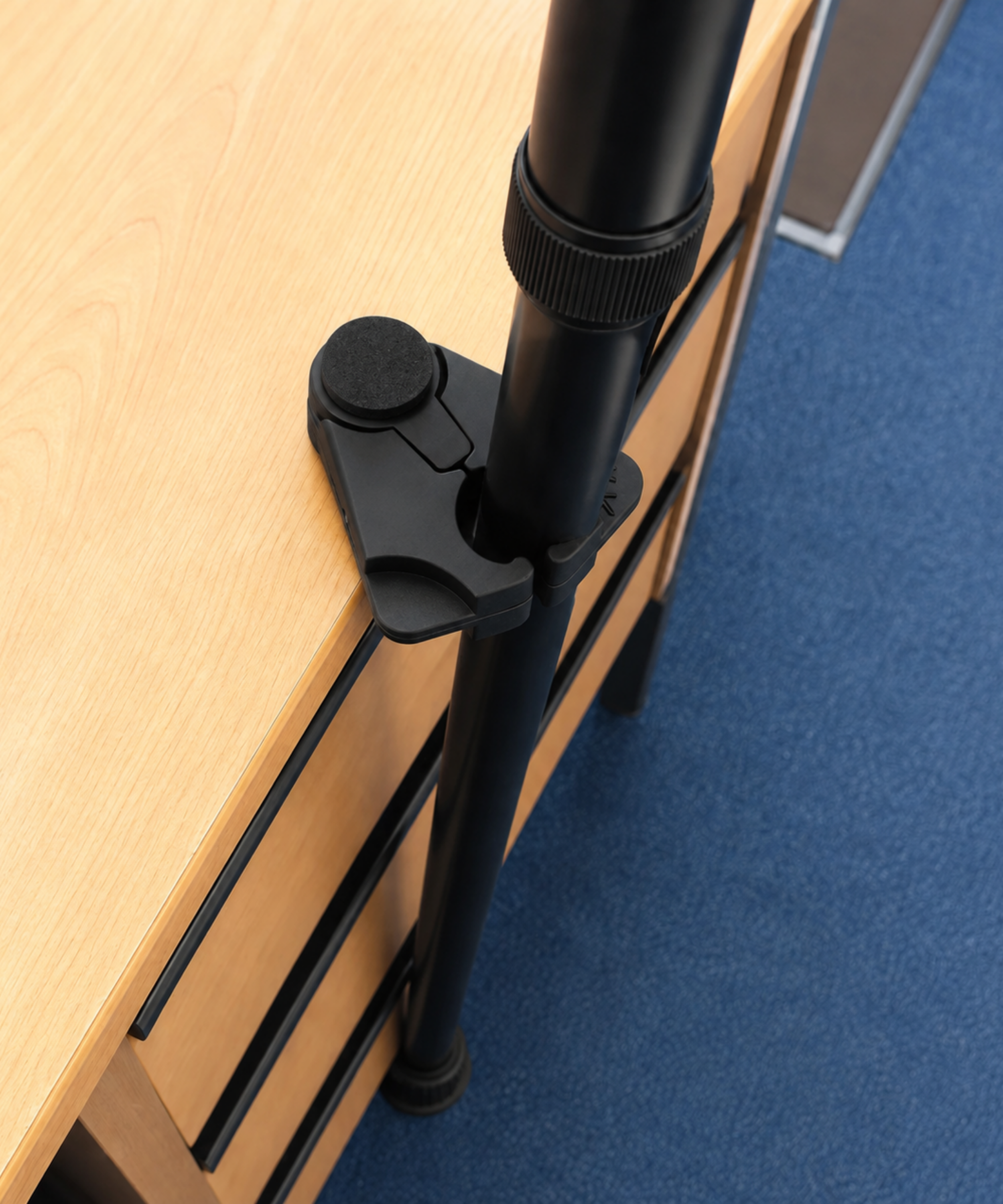 cane holder clamped to a desk edge holding a walking cane upright so it does not fall over